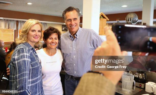 Republican U.S Senate candidate Mitt Romney and his wife Ann, has their picture taken with a supporter at Sills Cafe for a campaign stop on June 26,...