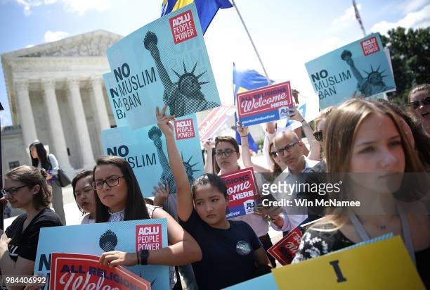 Protesters hols up signs that read 'No Muslim ban' against U.S. President Trump's travel ban gather outside the U.S. Supreme Court as the court...