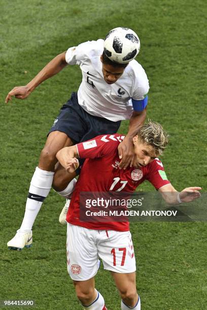 France's defender Raphael Varane heads the ball ahead of Denmark's defender Jens Stryger Larsen during the Russia 2018 World Cup Group C football...