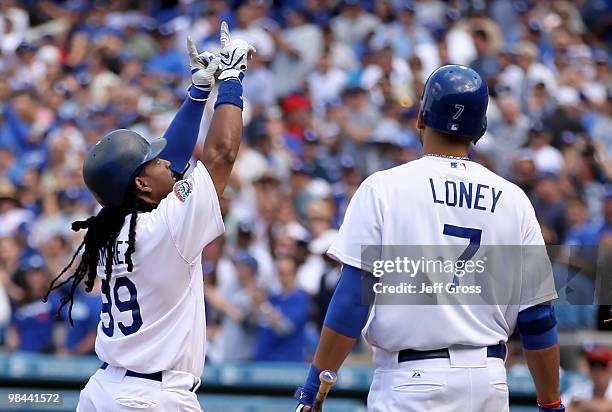 Manny Ramirez of the Los Angeles Dodgers celebrates a solo homerun in the fourth inning as teammate James Loney looks on during the home opener game...