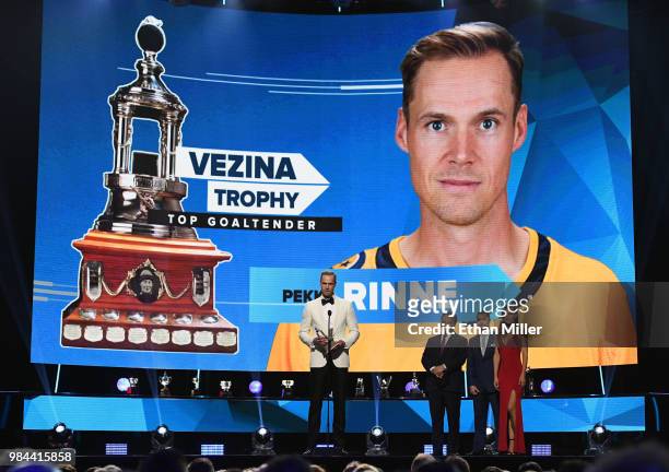 Pekka Rinne of the Nashville Predators accepts the Vezina Trophy, given to the top goaltender, as actor Jim Belushi and accountant Scott Foster look...