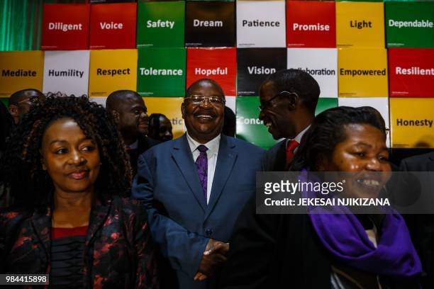 Obert Mpofu of Zanu PF shakes hands with Lovemore Madhuku of the NCA party during the national peace pledge signing hosted by the National Peace and...