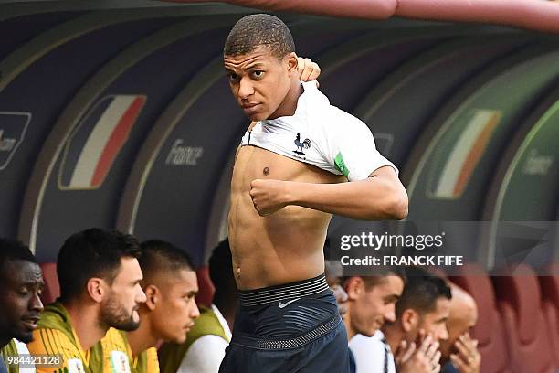 France's forward Kylian Mbappe puts on a jersey during the Russia 2018 World Cup Group C football match between Denmark and France at the Luzhniki...