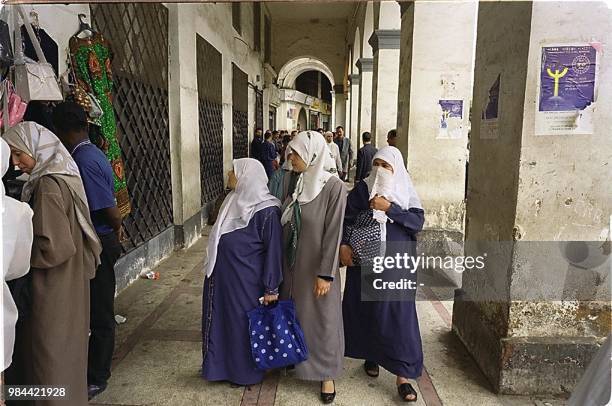 Picture taken in May 2000, shows women looking at the goods displayed by a street vendor, on the Martyrs' square in the Kasbah quarter in Algiers....