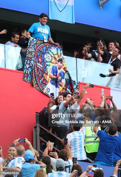 Argentina legend Diego Maradona holds a flag of himself as fans react prior to the 2018 FIFA World Cup Russia group D match between Nigeria and...