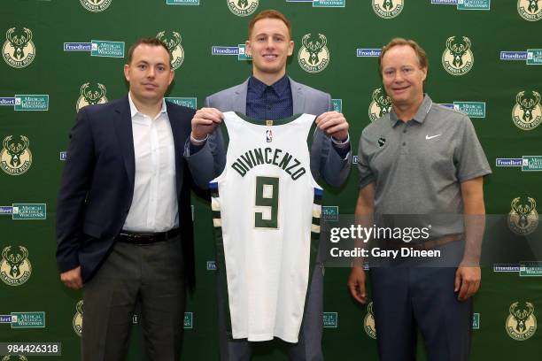 Milwaukee Bucks general manager Jon Horst and head coach Mike Budenholzer pose for a photo with Donte DiVincenzo during a press conference on June...