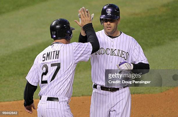 Seth Smith is welcomed home by starting pitcher Greg Smith of the Colorado Rockies who scored on Seth Smith's two run home run in the third inning...
