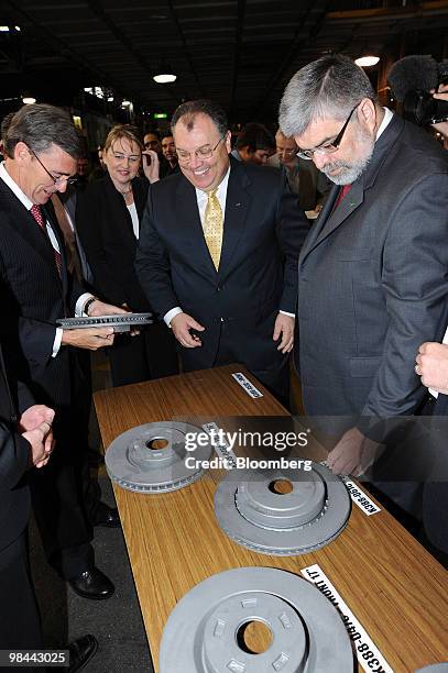 Marin Burela, president and chief executive officer of Ford Australia, center, shows brake rotor samples to John Brumby, premier of the state of...