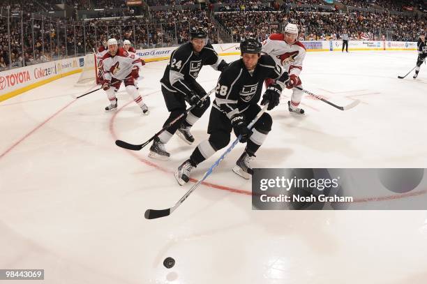 Jarret Stoll and Alexander Frolov of the Los Angeles Kings go for the puck against the Phoenix Coyotes on April 8, 2010 at Staples Center in Los...