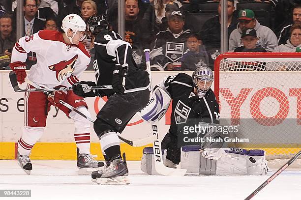Jonathan Quick of the Los Angeles Kings reaches to make the save while teammate Drew Doughty plays defense against Matthew Lombardi of the Phoenix...