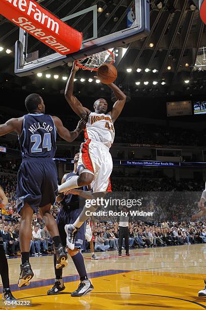 Anthony Tolliver of the Golden State Warriors dunks the ball against Paul Millsap of the Utah Jazz on April 13, 2010 at Oracle Arena in Oakland,...