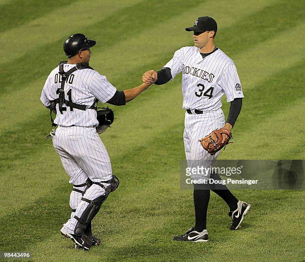 Catcher Miguel Olivo and relief pitcher Matt Belisle of the Colorado Rockies celebrate after defeating the New York Mets during Major League Baseball...