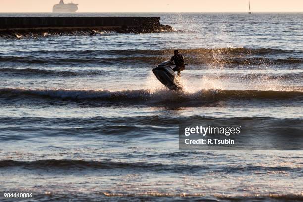 young guy cruising in the baltic sea  on a jet ski during sunset - jet ski ストックフォトと画像