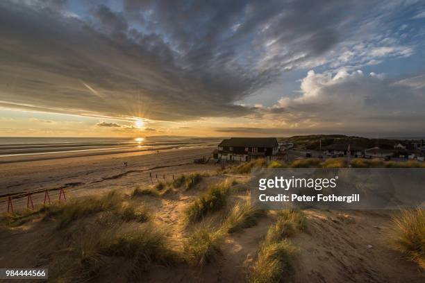 sandy beach during sunset in sussex, england. - east sussex imagens e fotografias de stock
