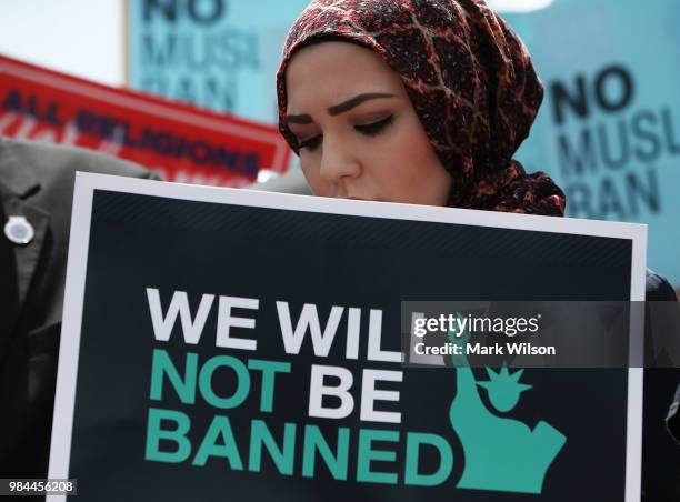 Women participates in demonstration against U.S. President Trump's travel ban as protesters gather outside the U.S. Supreme Court following a court...