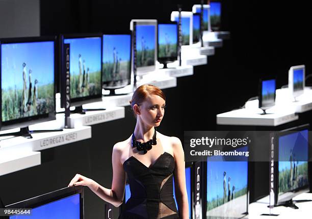 Model poses in front of Toshiba Corp.'s "LED Regza" liquid crystal display televisions displayed at an unveiling in Tokyo, Japan, on Wednesday, April...