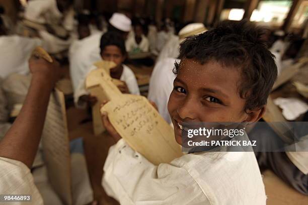 Sudanese Sufi student holds his wooden board or Lawha as he recites verses of the Koran at the Qadiriya Badiriya Sufi mosque in the village of Umm...