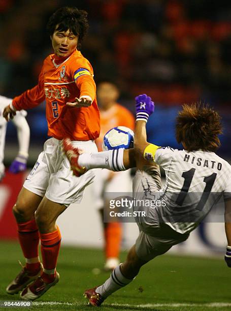 Liu Jindong of China's Shandong Luneng challenges for the ball with Sato Hisato of Japan's Sanfrecce Hiroshima during the AFC Champions League match...