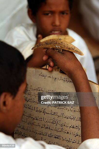 Sudanese Sufi student recites verses of the Koran written on his wooden board or "lawha" at the Qadiriya Badiriya Sufi mosque in the village of Umm...