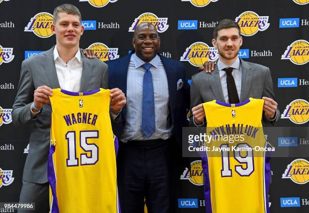 Magic Johnson, the Los Angeles Lakers president of basketball operations, stands with the team's 2018 NBA draft picks Moritz Wagner and Sviatoslav...