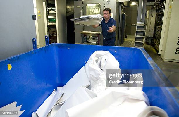 Printer Mark Crawley throws discarded newspaper in to a recycling bin at Trinity Mirror's factory in Watford, U.K., on Tuesday, April 13, 2010....