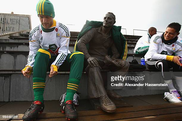 Matthew Booth of the South African national football team sits next to a statue of Adi Dassler, founder of adidas company prior to training session...