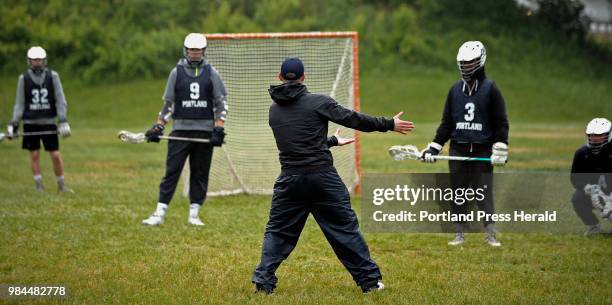 Portland boys' lacrosse coach Mike DiFusco explains an offensive drill during a rainy practice Monday. Portland has had a turnaround season. The team...