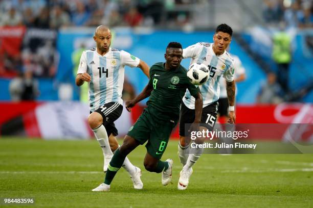 Oghenekaro Etebo of Nigeria is challenged by Javier Mascherano and Enzo Perez of Argentina during the 2018 FIFA World Cup Russia group D match...