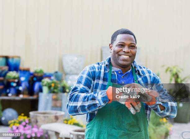 mature african-american man working in plant nursery - chubby man shopping stock pictures, royalty-free photos & images