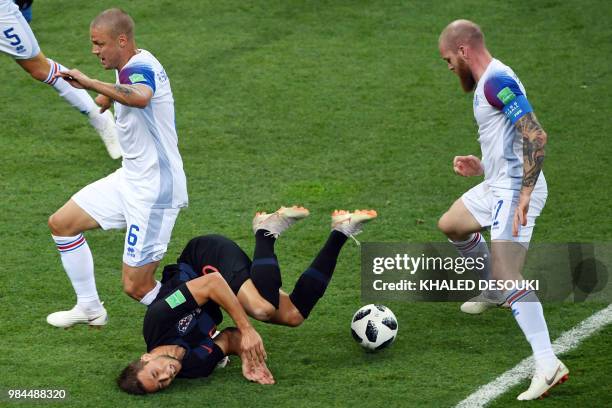 Croatia's forward Marko Pjaca falls after challenging Iceland's defender Ragnar Sigurdsson and Iceland's midfielder Aron Gunnarsson during the Russia...