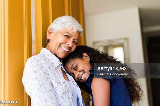 Lovely latin grandmother and granddaughter smiling at camera
