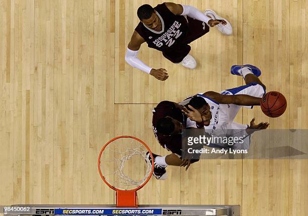 John Wall of the Kentucky Wildcats drives for a shot attempt against Jarvis Varnado and Barry Stewart of the Mississippi State Bulldogs during the...