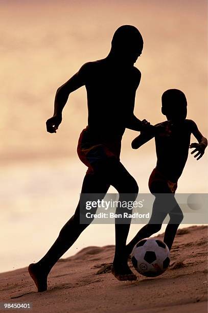 Two boys play football on the beach on 1 February 2000 in Ada, Ghana.