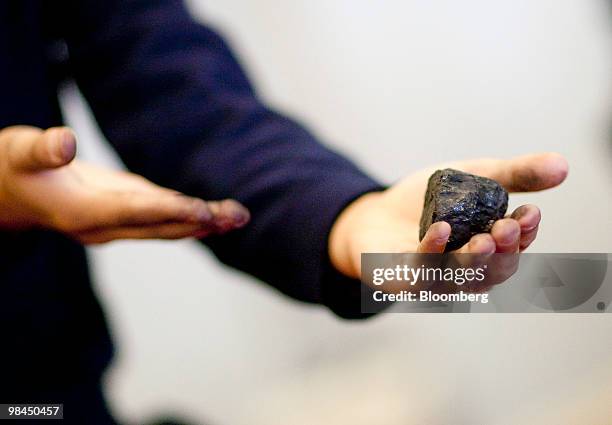 Protestor presents a piece of coal to executives during a hearing on coal energy in Washington, D.C., U.S., on Wednesday, April 14, 2010. A hearing...