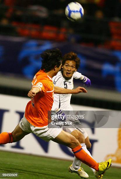 Yuan Weiwei of China's Shandong Luneng challenges for the ball with Makino Tonoaki of Japan's Sanfrecce Hiroshima during the AFC Champions League...