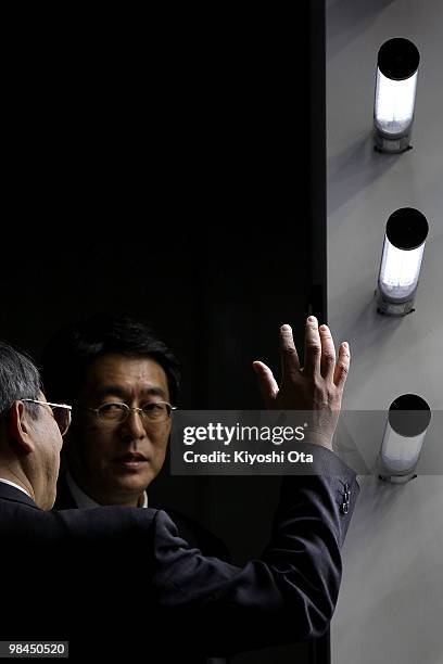 Visitors look at a display of Sanko Denki Sangyo Corp.'s light emitting diode security lightings during the second LED/OLED Lighting Technology Expo...