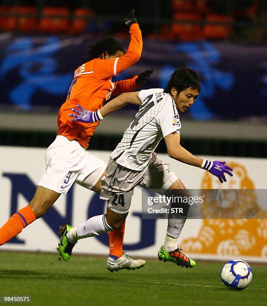 Santos Carlos of China's Shandong Luneng vies with Moriwaki Ryota of Japan's Sanfrecce Hiroshima during the AFC Champions League match in Jinan, east...