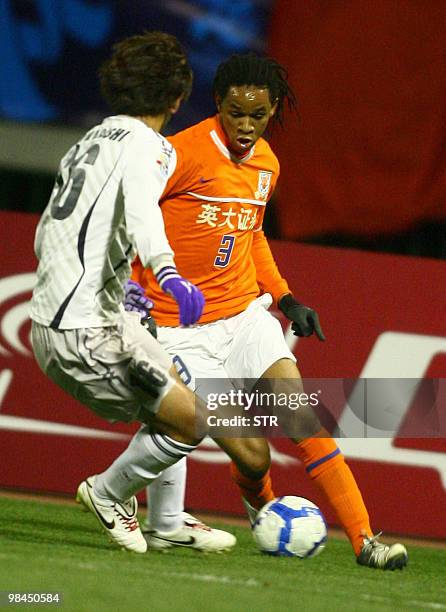 Santos Carlos of China's Shandong Luneng vies with Yamagishi Satoru of Japan's Sanfrecce Hiroshima during the AFC Champions League match in Jinan,...