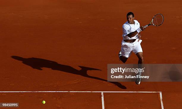 Jo-Wilfried Tsonga of France plays a forehand with partner Richard Gasquet of France in their doubles match against Marcel Granollers and Tommy...