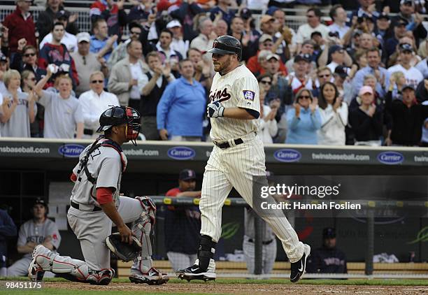 Jason Kubel of the Minnesota Twins crosses homeplate after hitting the first home run at Target Field in the seventh inning as Victor Martinez of the...