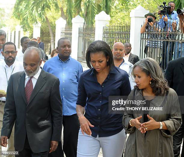 First Lady Michelle Obama speaks with Haitian Prime Minister Rene Preval and his wife Elisabeth Delatour Preval during a surprise visit to Haiti on...