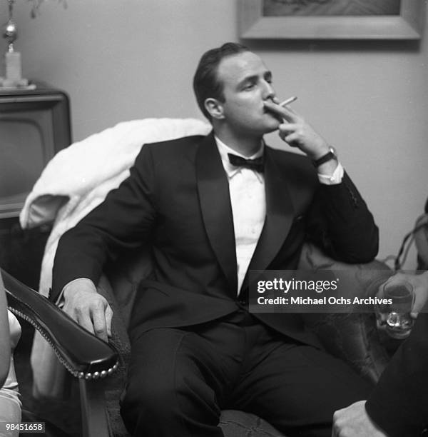 Actor Marlon Brando smokes a cigarette as he attends a party on February 24, 1955 in Los Angeles, California.