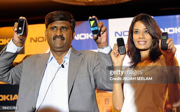 Regional General Manager South Nokia India T.S. Sridhar and a model pose with newly-launched Nokia mobile phones during a press conference in...