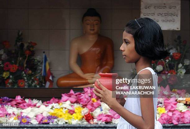 Sri Lankan Buddhist devotee offers prayers at a Buddhist Temple in celebration of the traditional Sinhala and Tamil New Year in Colombo on April 14,...