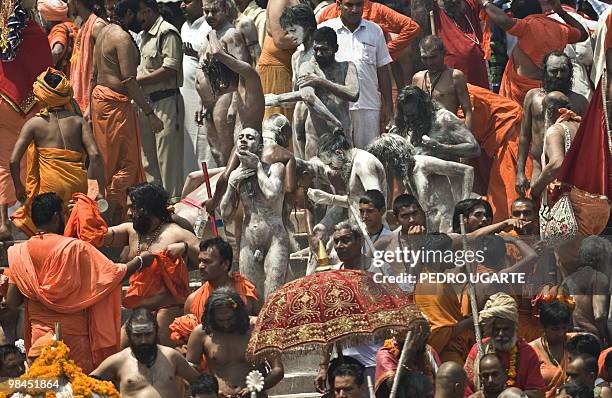 Hindu Sadhus cover their bodies with mud after a bath at the river Ganges during the Kumbh Mela festival in Haridwar on April 14, 2010. The Kumbh...