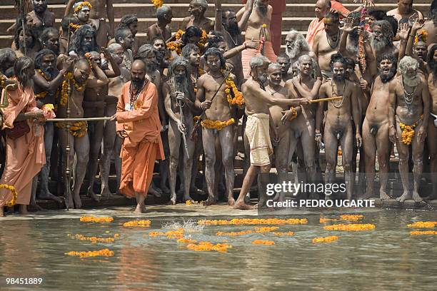 Hindu Sadhus, or holy men, wait on the banks of the river Ganges moments before taking a bath during the Kumbh Mela festival in Haridwar on April 14,...