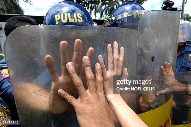 Hacienda Luisita farmers along with student activists scuffle with policemen during a rally near the house of presidential candidate and senator...