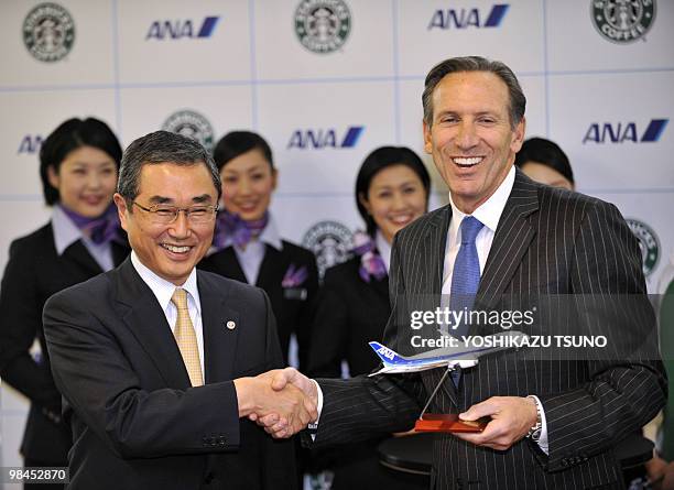 Starbucks chairman and CEO Howard Schultz shakes hands with Shinichiro Ito, president of Japanese air carrier All Nippon Airways during a launching...