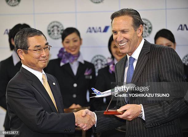 Starbucks chairman and CEO Howard Schultz shakes hands with Shinichiro Ito, president of Japanese air carrier All Nippon Airways during a launching...