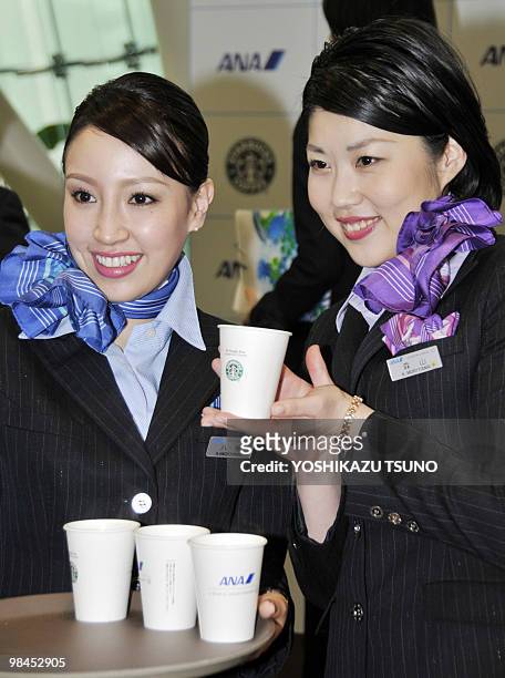 All Nippon Airways flight attendants display Starbucks new instant coffee "VIA" during a launching ceremony at Tokyo's Haneda airport on April 14,...